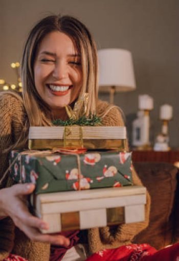 Shot of a young woman with holding Xmas presents and smiling Shot of a young woman with holding Xmas presents and smiling